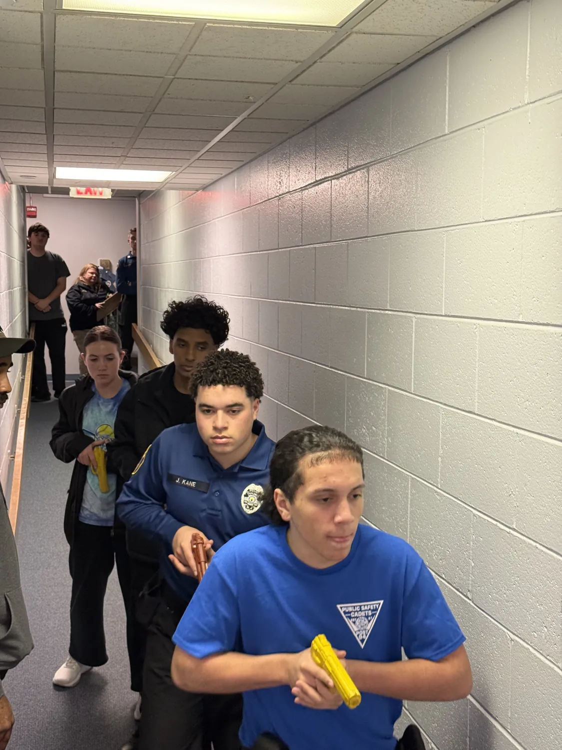 An officer mentoring cadets during an indoor training session