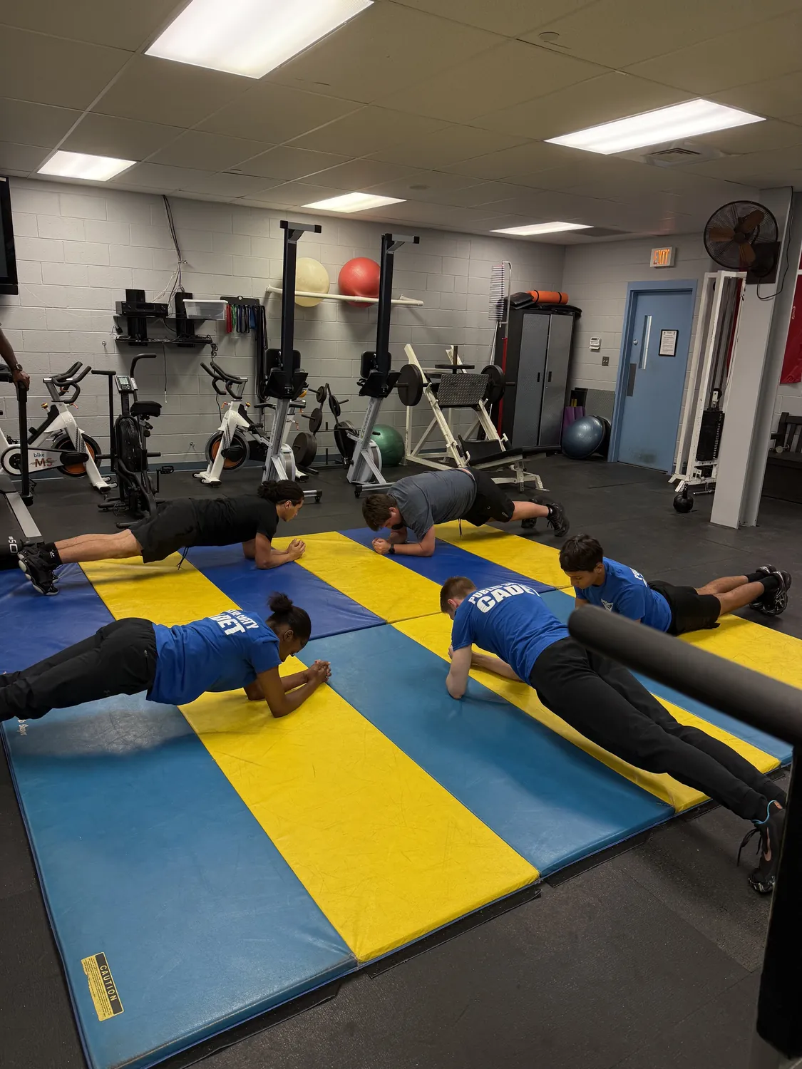 Cadets doing push-ups on mats during physical training